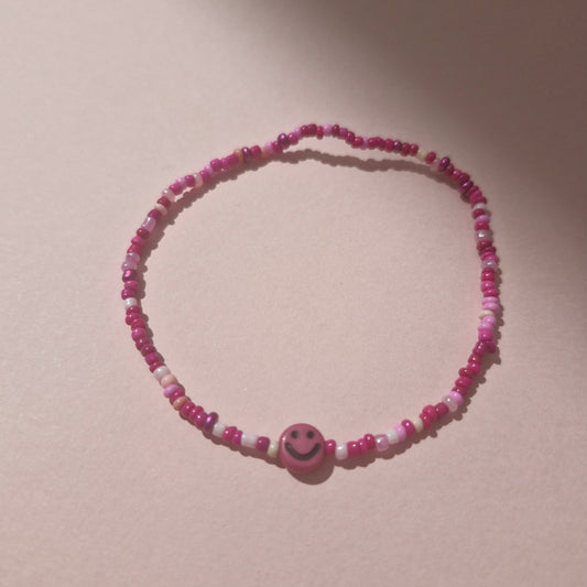 Pink Friendship Bracelet With A Bright Pink Smiley Face