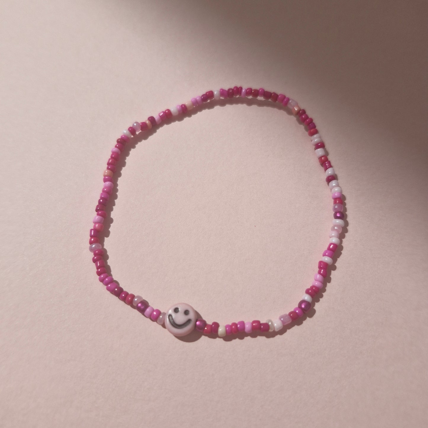 Pink Friendship Bracelet With A Light Pink Smiley Face