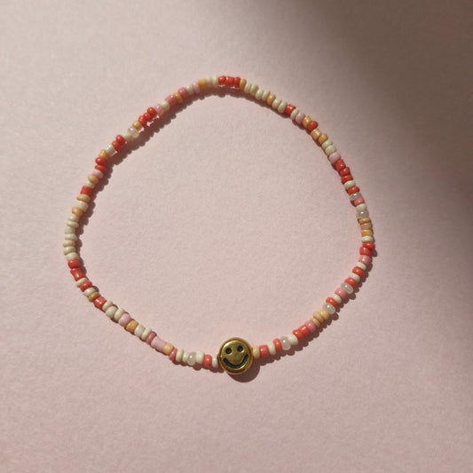 Coral/Peach Friendship Bracelet With A Gold Smiley Face