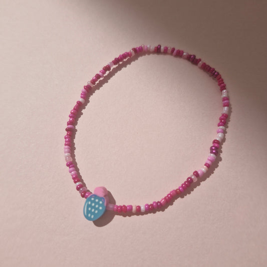 Pink Friendship Bracelet With A Blue Fruit