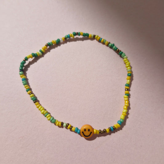 Green/Yellow Friendship Bracelet With An Orange Smiley Face