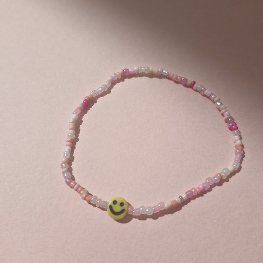 Light Pink Friendship Bracelet With A Yellow Smiley Face