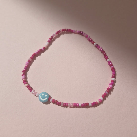 Pink Friendship Bracelet With A Blue Smiley Face