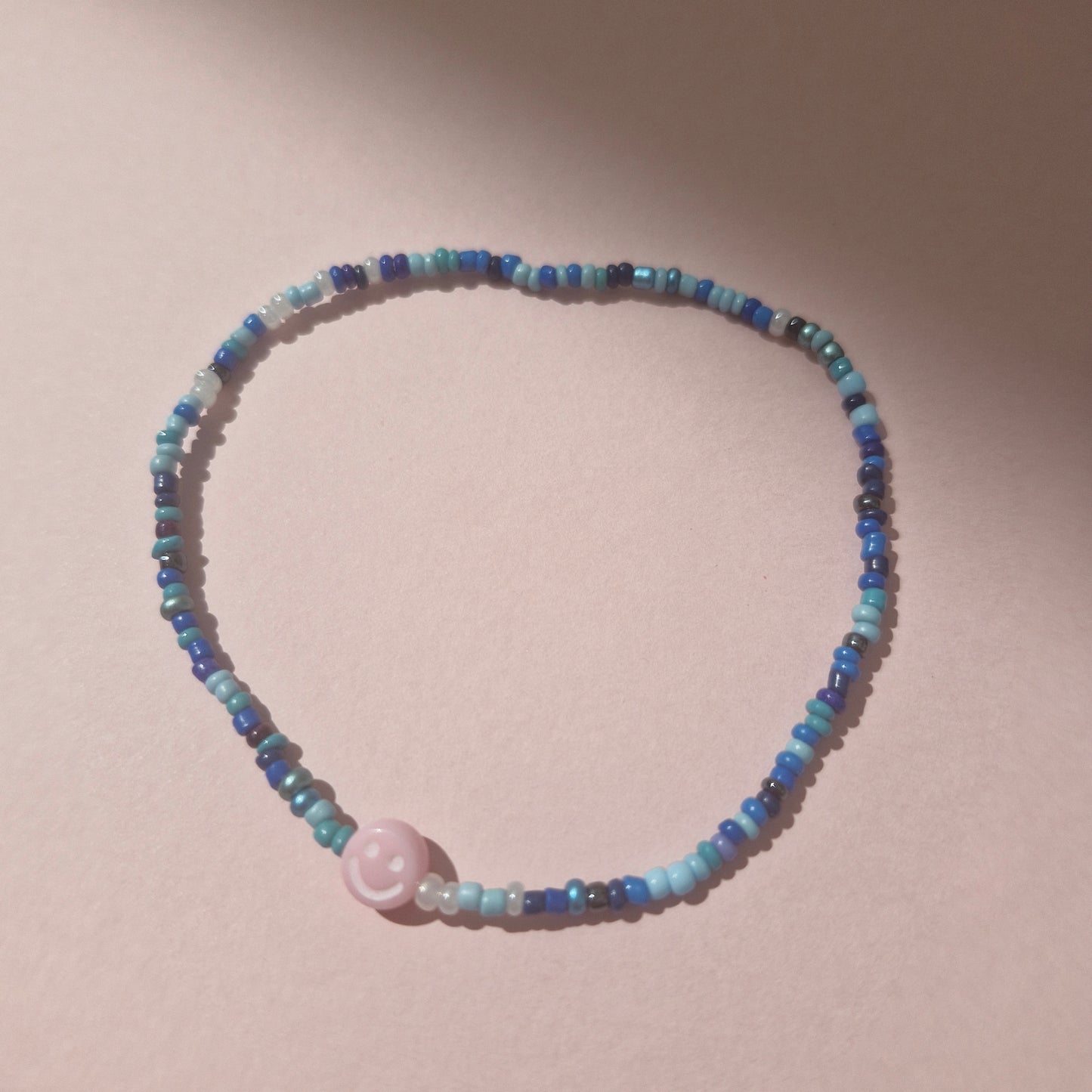 Blue Friendship Bracelet With A Light Pink Smiley Face