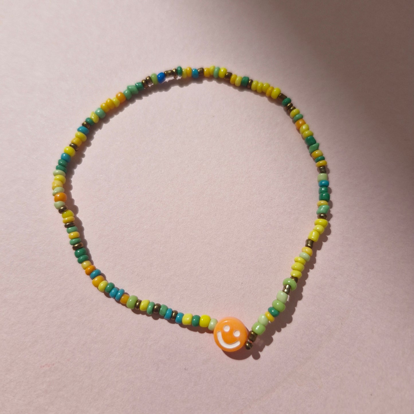 Green/Yellow Friendship Bracelet With An Orange Smiley Face