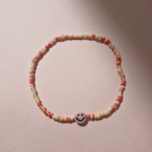 Coral/Peach Friendship Bracelet With A Pink Smiley Face