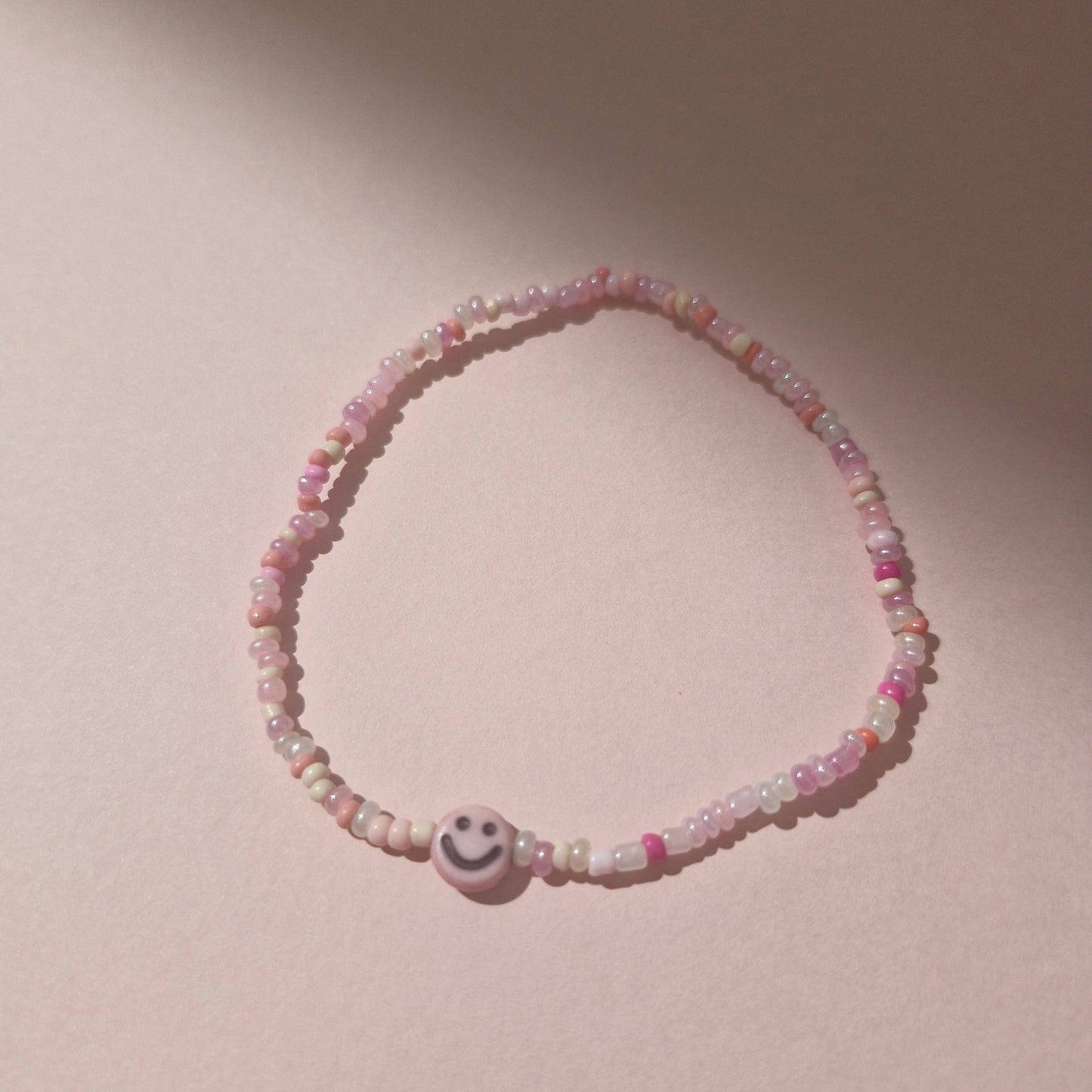 Light Pink Friendship Bracelet With A Light Pink Smiley Face